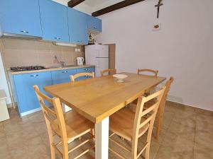 a wooden table in a kitchen with blue cabinets at Holiday Home Micheli by Interhome in Gornji Humac