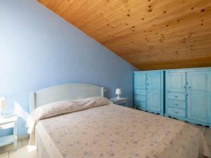 - une chambre avec un lit avec des placards bleus et un plafond en bois dans l'établissement Apartment Fico by Interhome, à Terzorio