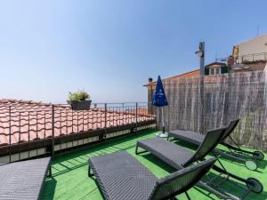 - un balcon avec des chaises et un parasol donnant sur l'océan dans l'établissement Apartment Fico by Interhome, à Terzorio