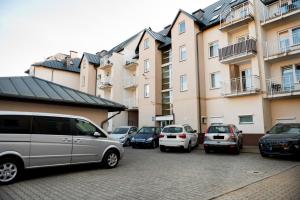 a group of cars parked in a parking lot next to buildings at Turkus Holiday in Pobierowo