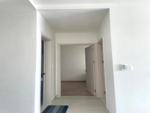 an empty hallway with white walls and a white floor at Compass One Building - Luxury Apartments in Ấp Phú Thọ