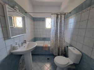 a bathroom with a sink and a toilet and a tub at Maison Du Lac in Kanoni +28 photos