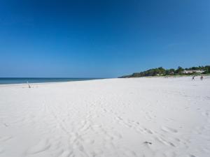a white beach with footprints in the sand at Holiday Home Domki Miłe-1 by Interhome in Choczewo