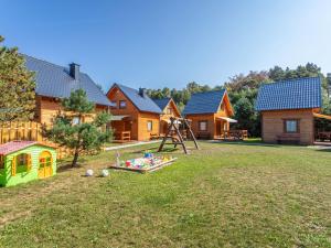 a yard with a house and a playground at Holiday Home Domki Miłe-1 by Interhome in Choczewo