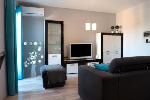 a living room with a couch and a television at Turkus Holiday in Pobierowo
