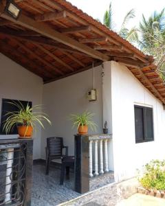 un patio con dos macetas en una casa en Tulsi Authentic Homestay - Beach Village Goa, en Canacona