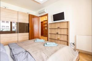 a bedroom with a bed and a tv on the wall at Danube Dream Superb view & garage in Budapest