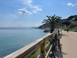 uma bicicleta estacionada numa cerca junto ao oceano em Apartment Casa dei Gerani by Interhome em Varazze