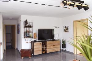 a living room with a flat screen tv on a wooden entertainment center at Ferienwohnung Familie Strehl in Frickingen