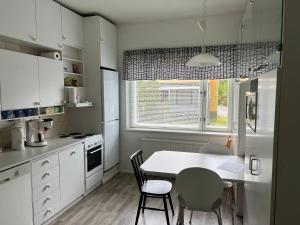 a kitchen with a table and chairs and a window at Apartment Huvilakatu in Kokkola