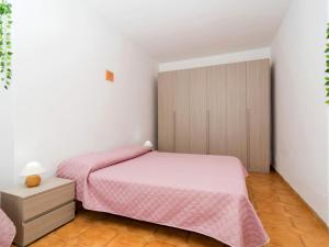 - une chambre avec un lit rose et une armoire en bois dans l'établissement Apartment Miky by Interhome, à Massa Lubrense