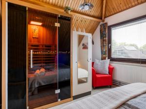 Habitación con cama y silla roja en Holiday Home Haus Anni by Interhome en Wolphaartsdijk