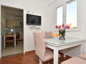 a living room with a dining room table with flowers on it at Holiday Home Irma by Interhome in Sukošan