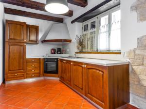 cocina con armarios de madera y suelo de baldosa naranja en Holiday Home Villa Farfalla by Interhome, en Tinjan