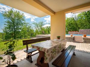 um pátio com uma mesa e bancos e uma vista em Holiday Home Korina by Interhome em Klana