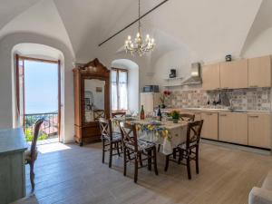 eine Küche mit einem Tisch und Stühlen im Zimmer in der Unterkunft Locazione Turistica Marina by Interhome in Terzorio