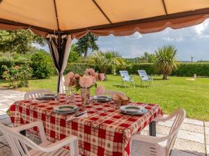 uma mesa com uma toalha de mesa xadrez e flores sobre ela em Holiday Home Marinpietri by Interhome em Roccastrada