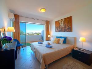 a bedroom with a large bed and a large window at Apartment Full moon by Interhome in Portimão