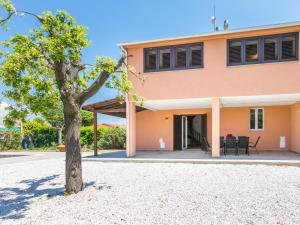 une maison avec un arbre devant dans l'établissement Holiday Home Tuscania by Interhome, à Bibbona