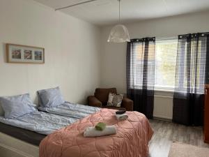 a bedroom with a bed and a chair and a window at Apartment Huvilakatu in Kokkola