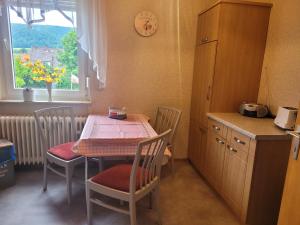 Una cocina con mesa y sillas y una cocina con ventana. en Köster & Hahnemann, en Rinteln