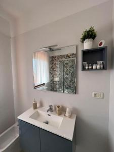 a bathroom with a sink and a mirror at La casa verde di Chicchi in Elmas