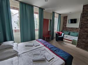 a bedroom with a large bed and a living room at Fortuna Hotel in Miskolctapolca +46 photos