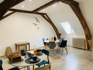 uma sala de jantar com duas mesas e cadeiras em Les Chambres de La Varenne em La Flèche
