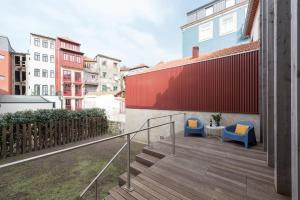 un balcón con 2 sillas y una mesa en un edificio en AgapeStay Family House, en Oporto