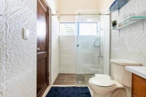 a bathroom with a toilet and a glass shower at Paramount Views in San Felipe de Puerto Plata