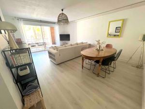 a living room with a table and a couch at Appartement avec piscine in Calvi