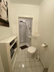 a white bathroom with a toilet and a shower at zentrale Ferienwohnung am Koblenzer HBF - Nah am Rhein in Koblenz