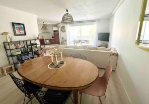 a living room with a table and a couch at Appartement avec piscine in Calvi