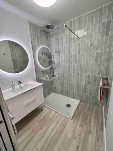 a bathroom with a sink and a shower with a mirror at Appartement avec piscine in Calvi +5 photos