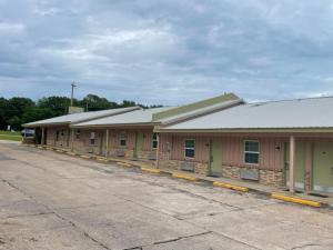 a building with a row of stalls in a parking lot at Village Inn in Ada