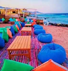 a beach with tables and chairs and the ocean at Ghazala Boutique Hotel Dahab in Dahab