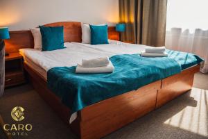 uma cama num quarto de hotel com almofadas azuis em Hotel CARO em Poznań