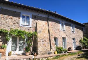 un antiguo edificio de ladrillo con ventanas y gatos sentados fuera en Il Colle Calci, en Calci