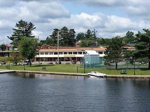 a boat in the water in front of a building at Clark's Beach Motel in Old Forge