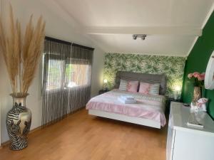 1 dormitorio con 1 cama y un jarrón de flores en Villa Omnia, en Varna