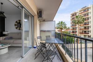 einen Balkon mit einem Tisch und Stühlen darauf in der Unterkunft CMG - Bel appartement avec balcon - 200m de la plage in Juan-les-Pins