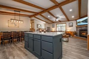 a kitchen with a large island in a room with a fireplace at *Entire House • Sleeps 9 • Hot tub • Pets Welcome* in McHenry