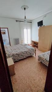 een slaapkamer met 2 bedden, een tafel en een raam bij Hotel Ristorante Miramonti in Consuma