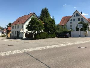 a street with two houses and a car on the road at Pension Grüner Baum 
