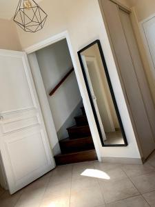a hallway with a door and a mirror and stairs at Maison ancienne très lumineuse axe Reims / Laon 