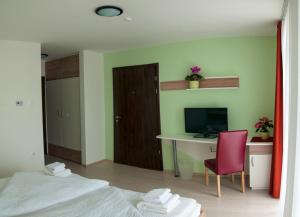 Habitación con escritorio, ordenador y silla roja. en Hotel Pallone en Balatonfüred