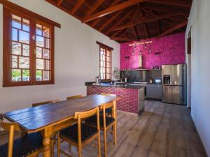 cocina con mesa de madera y paredes rosas en Beautiful beach house in traditional Canarian style, en Puerto de Mogán