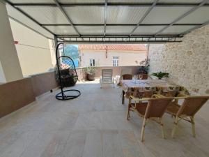 a patio with a table and chairs and a building at Apartments Turan Centrally Located with Free Parking in Igrane