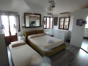 a bedroom with two beds and a mirror at CA' VERDEMARE in Varazze