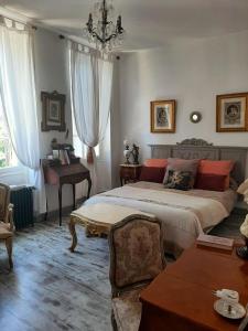 una camera con letto, tavolo e pianoforte di La Villa des Remparts a Labastide-dʼArmagnac